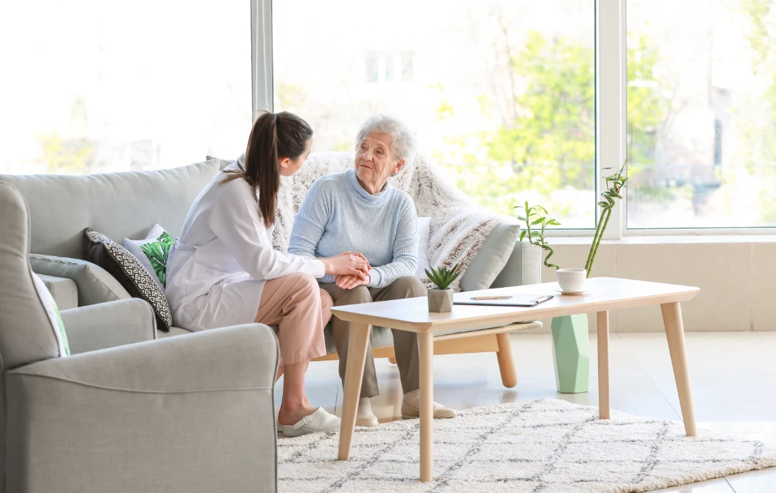 Carer sitting with an elderly lady at home